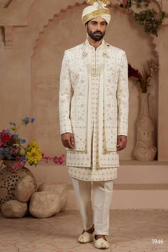 Cream heavy sherwani three-piece set with full hand embroidery, stone work, and resham thread detailing.