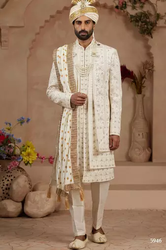 Cream heavy sherwani three-piece set with full hand embroidery, stone work, and resham thread detailing.