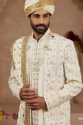 Cream heavy sherwani three-piece set with full hand embroidery, stone work, and resham thread detailing.