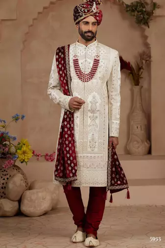 Cream heavy sherwani set with full hand embroidery, stone work, and resham thread detailing.