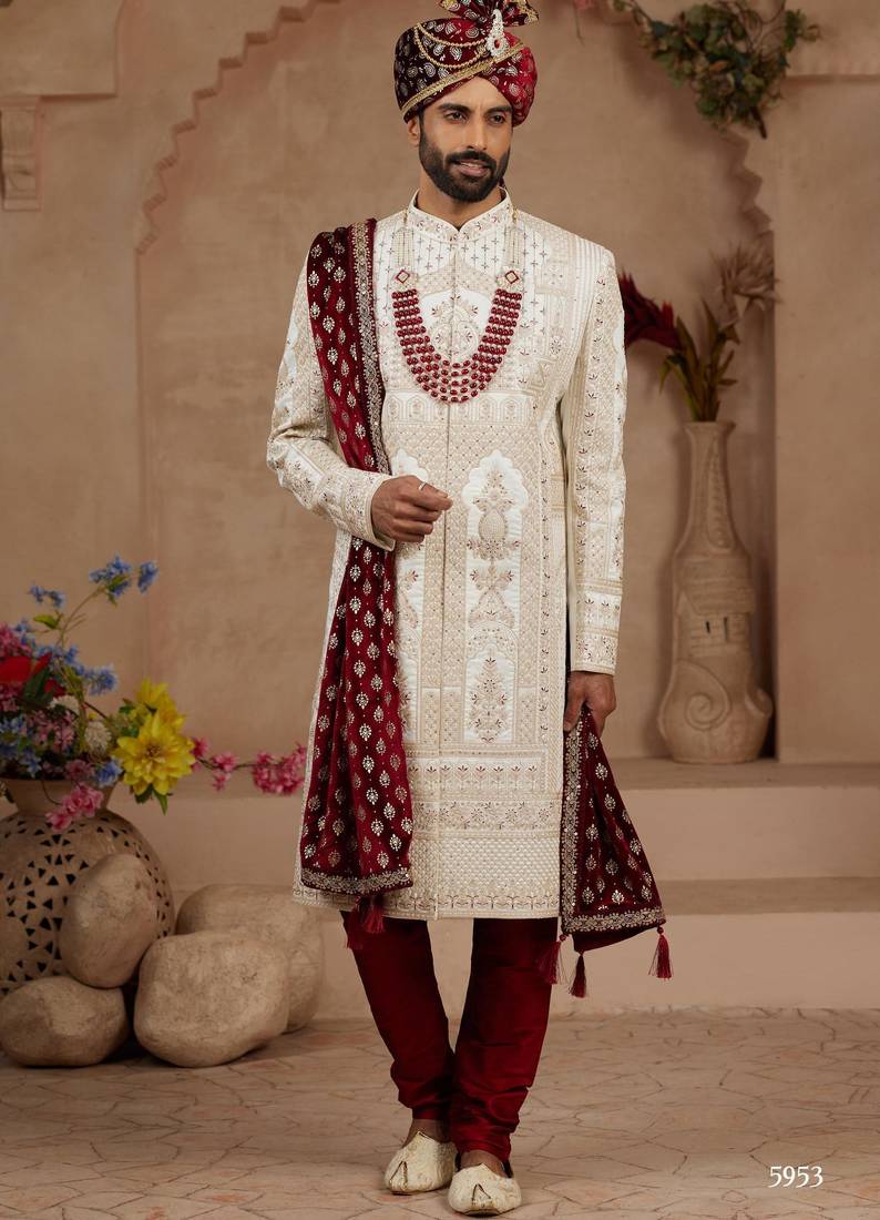 Cream heavy sherwani set with full hand embroidery, stone work, and resham thread detailing.