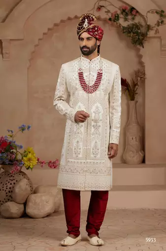 Cream heavy sherwani set with full hand embroidery, stone work, and resham thread detailing.