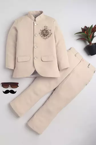 Boys cream lycra floral embroidered bandhgala blazer & trouser set with metal crest