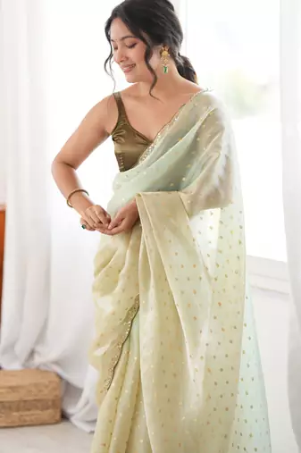 Olive tissue embellished saree with unstitched blouse piece.