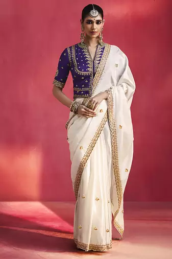 white silk blend saree with purple embroidered blouse & zari border