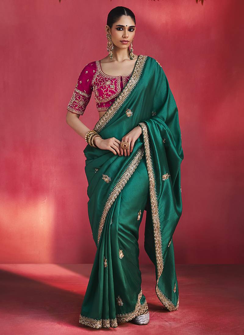bottle green silk blend saree with rani pink embroidered blouse & zari border