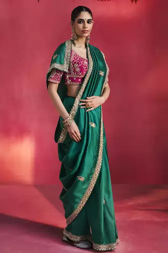 bottle green silk blend saree with rani pink embroidered blouse & zari border