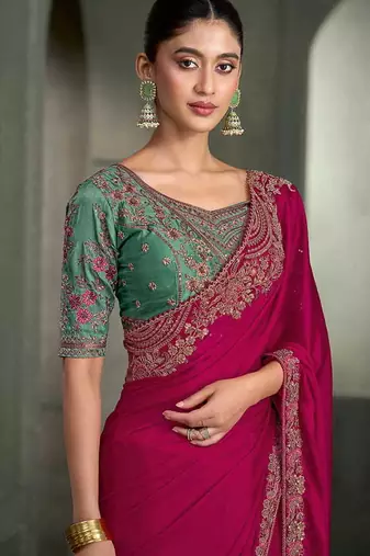 rani pink faux chiffon saree with green embroidered blouse