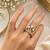 Elegant gold tone crown design statement ring with clear stone accents