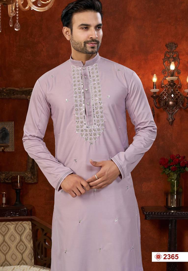 Purple soft silk kurta pajama set with beadwork on the neckline and thread embroidery on the hem.