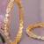 Swirling  solitaire gold plated diamond bangles