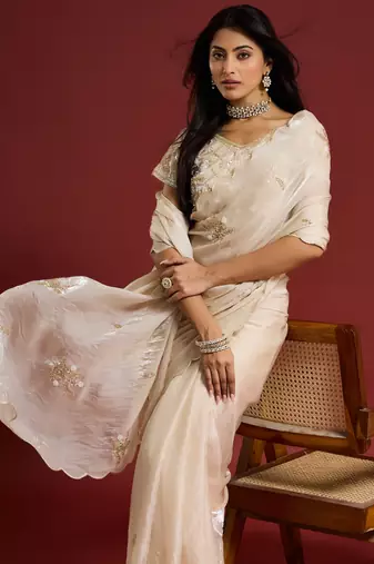 Cream tissue satin embellished saree with unstitched blouse piece.