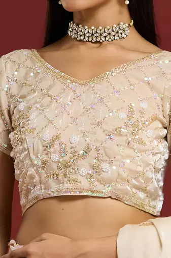 Cream tissue satin embellished saree with unstitched blouse piece.