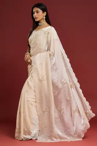 Cream tissue satin embellished saree with unstitched blouse piece.