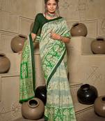 green green & cream-coloured ethnic motifs art silk ikat saree