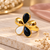 Gold-tone finish, glossy enamel petals, lightweight fit, flower design.