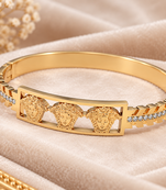 Gold-tone medusa bangle bracelet with crystal accents