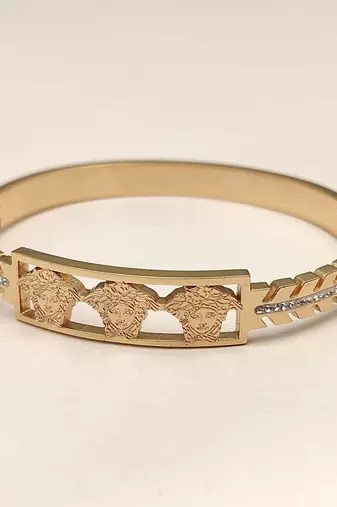 Gold-tone medusa bangle bracelet with crystal accents