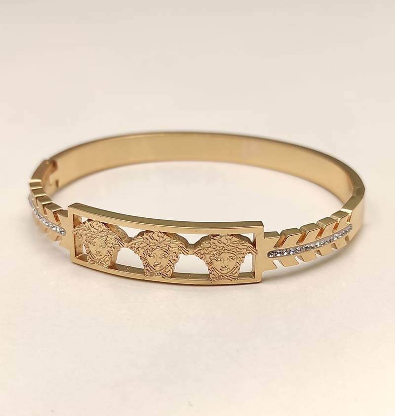 Gold-tone medusa bangle bracelet with crystal accents