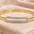 Gold-tone bangle bracelet with crystal oval centerpiece