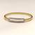 Gold-tone bangle bracelet with crystal oval centerpiece