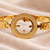 Gold-toned bangle bracelet with circular medallion & floral cutout