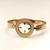 Gold-toned bangle bracelet with circular medallion & floral cutout