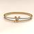 Gold-tone bangle bracelet with v logo charm and crystal accents