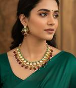 Gold plated kundan necklace set with green meenakari, red beads and crystal accents with earrings