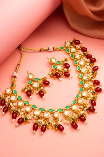 Gold plated kundan necklace set with green meenakari, red beads and crystal accents with earrings
