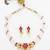 Gold plated multi-strand pearl necklace with red stone detail