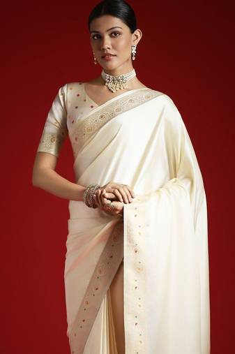 Cream cream solid zari woven design satin banarasi saree with matching blouse