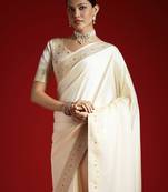 Cream cream solid zari woven design satin banarasi saree with matching blouse