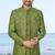 Olive green sherwani with gold detailing and cream trousers—ideal for celebrations.
