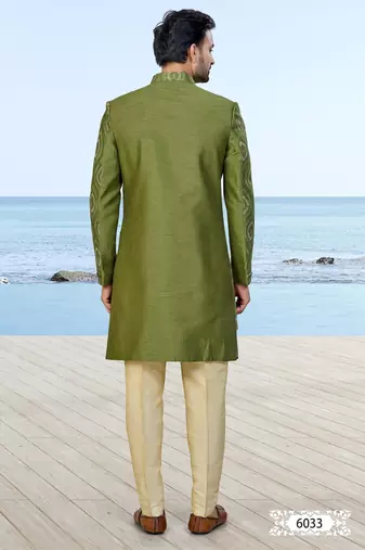 Olive green sherwani with gold detailing and cream trousers—ideal for celebrations.