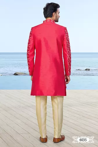 Red sherwani with gold detailing and cream trousers—perfect for weddings and celebrations.