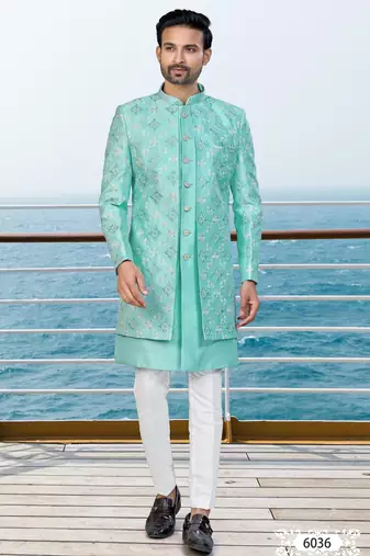 Turquoise sherwani with floral embroidery and white trousers—perfect for weddings.