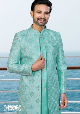 Turquoise sherwani with floral embroidery and white trousers—perfect for weddings. 3