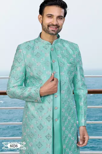Turquoise sherwani with floral embroidery and white trousers—perfect for weddings.