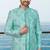 Turquoise sherwani with floral embroidery and white trousers—perfect for weddings.