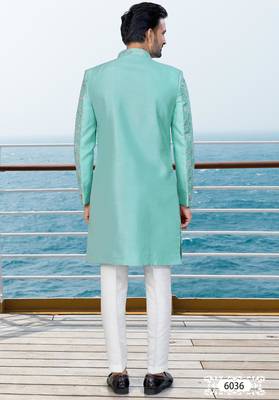 Turquoise sherwani with floral embroidery and white trousers—perfect for weddings. 4