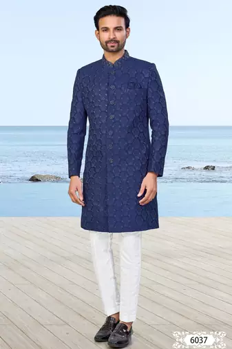 Navy blue sherwani with subtle texture, pocket square, and white trousers—ideal for weddings and formal events.