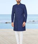 Navy blue sherwani with subtle texture, pocket square, and white trousers—ideal for weddings and formal events.