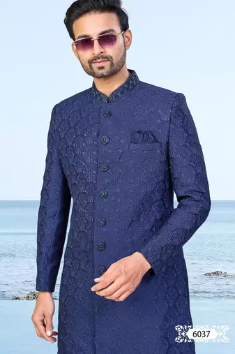 Navy blue sherwani with subtle texture, pocket square, and white trousers—ideal for weddings and formal events.