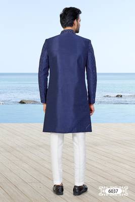 Navy blue sherwani with subtle texture, pocket square, and white trousers—ideal for weddings and formal events. 4
