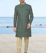 Green sherwani with geometric detailing, a pocket square, and gold-toned trousers—perfect for festive occasions.
