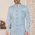Light blue sherwani with white embroidery and mirror work, paired with white trousers—perfect for weddings.