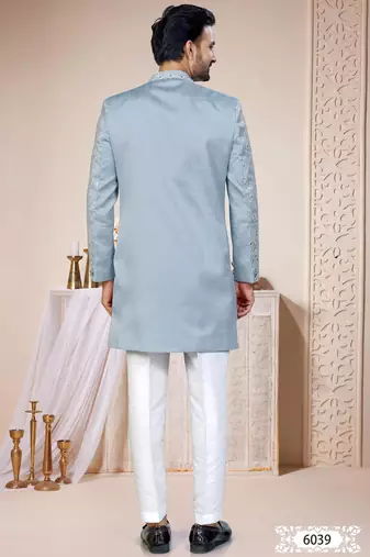 Light blue sherwani with white embroidery and mirror work, paired with white trousers—perfect for weddings.