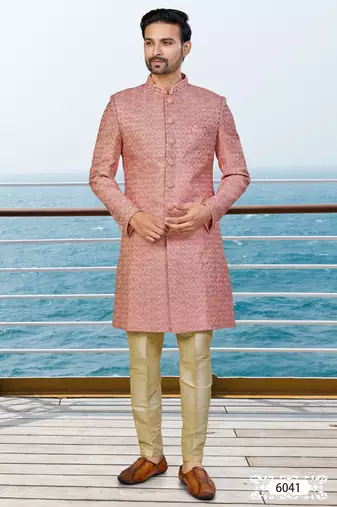 Peach sherwani with woven detailing and gold-toned trousers—perfect for weddings and celebrations.