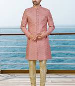 Peach sherwani with woven detailing and gold-toned trousers—perfect for weddings and celebrations.
